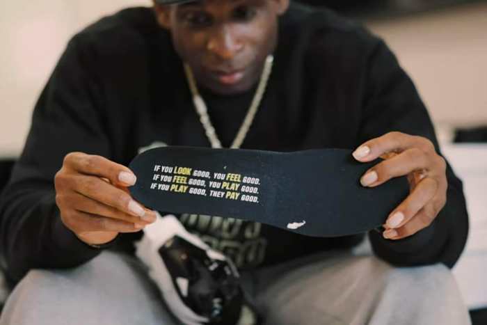 Deion Sanders hold Nike Diamond Turf 3 shoes